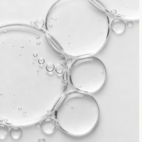 Clear drops of Babassu oil with a light gray background