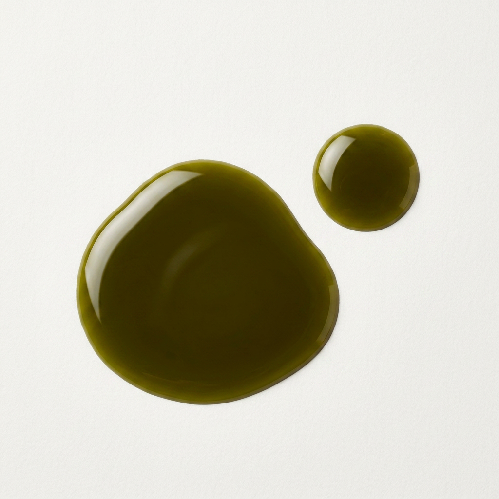 Two droplets of olive oil on a white background