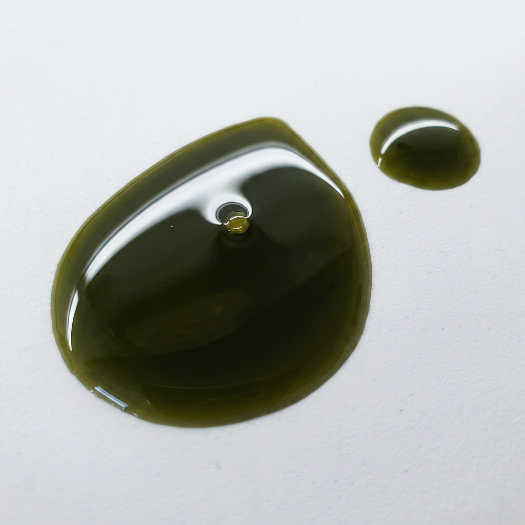 Green oil droplet on a white background