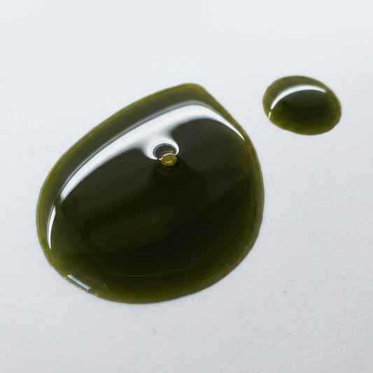 Green oil droplet on a white background